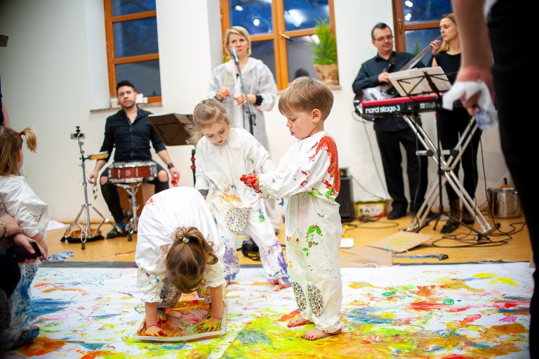 Dzieci ubrane w kombinezon GetDirty bawią się podczas koncerty dla dzieci.